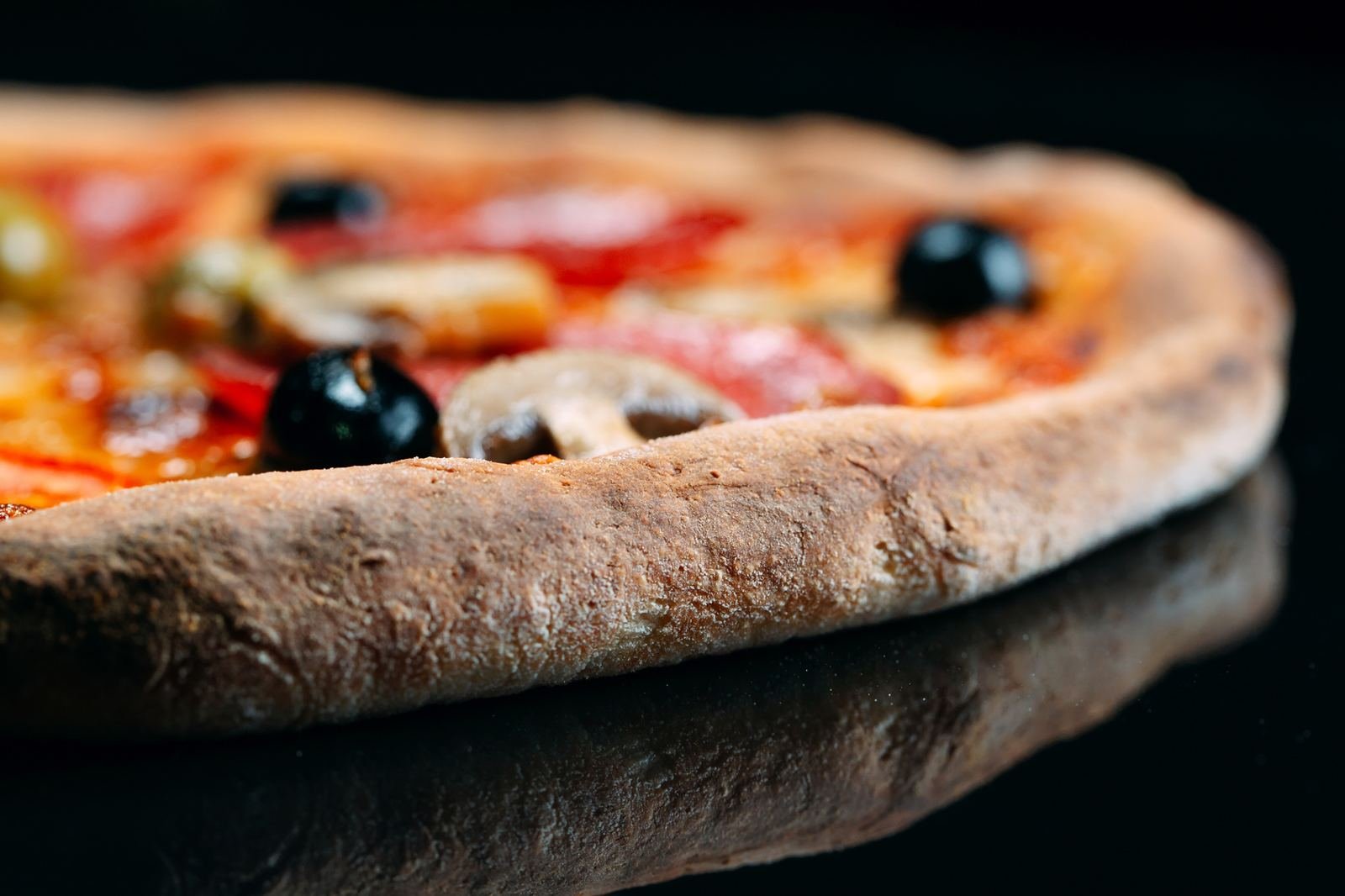 Close-up of a pizza crust with toppings